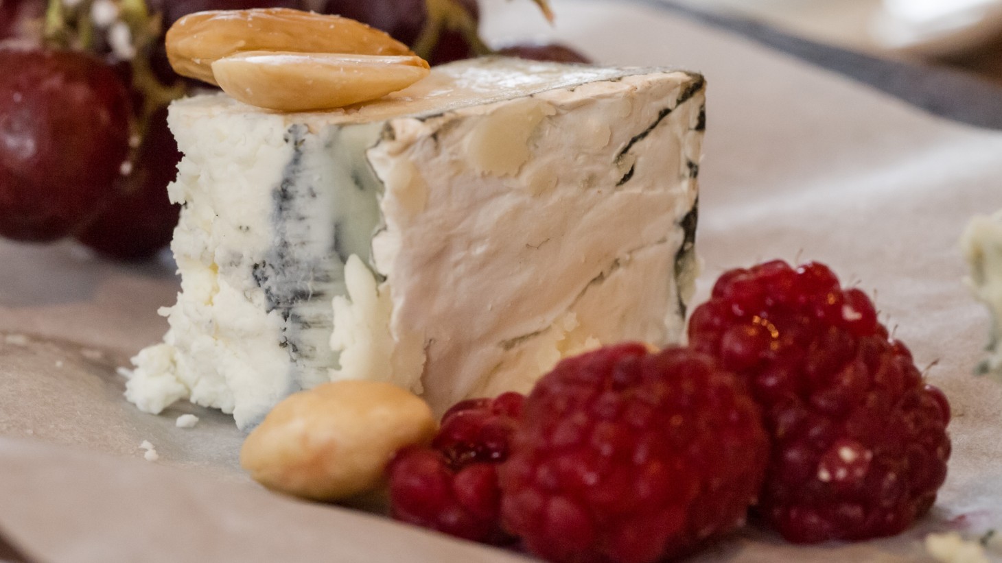 hunk of blue cheese with nuts and raspberries